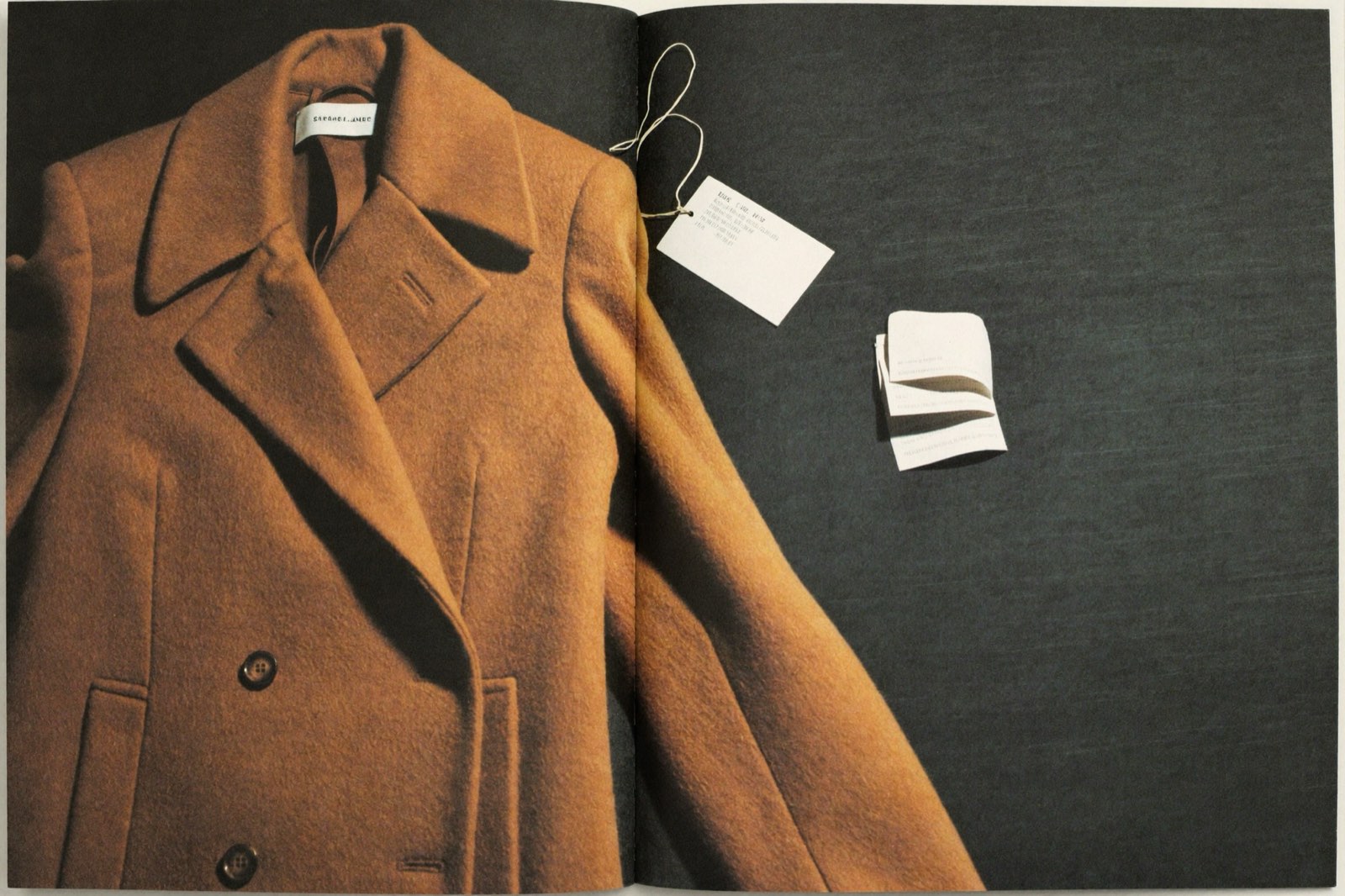 Camel wool coat flat lay with a price tag and folded receipt — the cost per wear math in one frame
