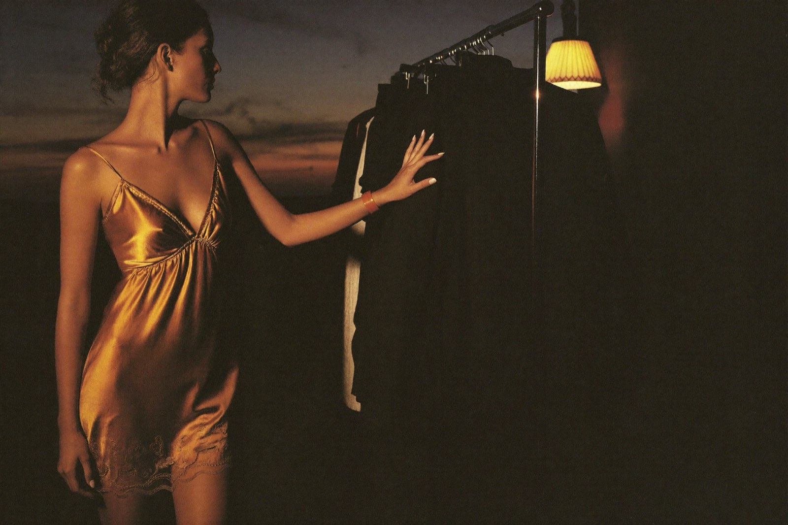 Woman standing before an overfull wardrobe at dawn with nothing to wear